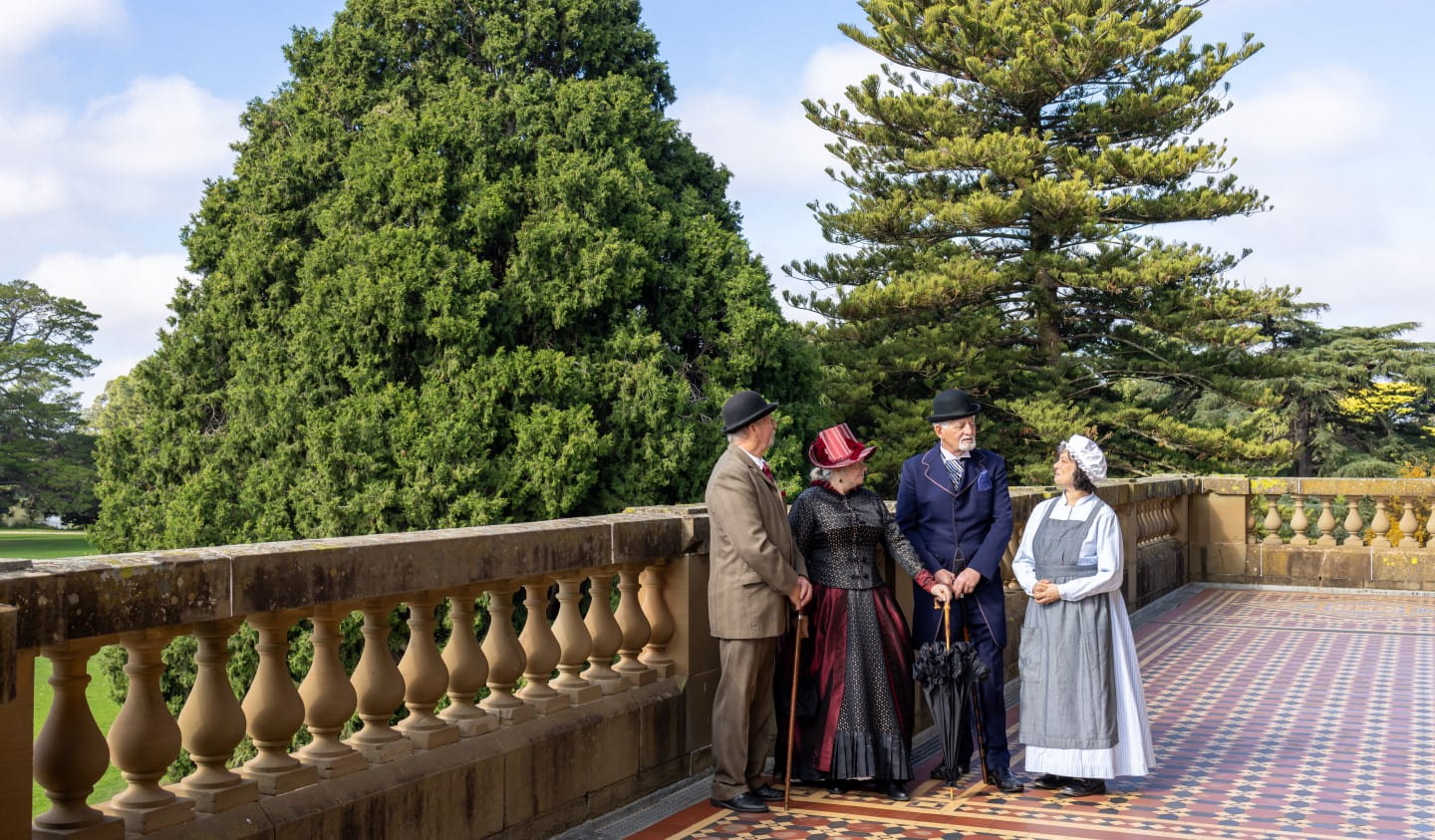 A group of people in historical costumes at Werribee Park mansion.