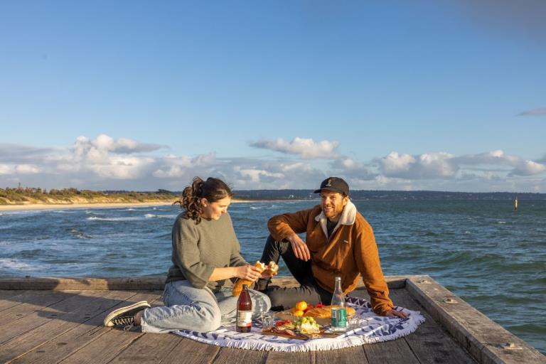 Couple enjoying a sunset picnic at Seaford Pier