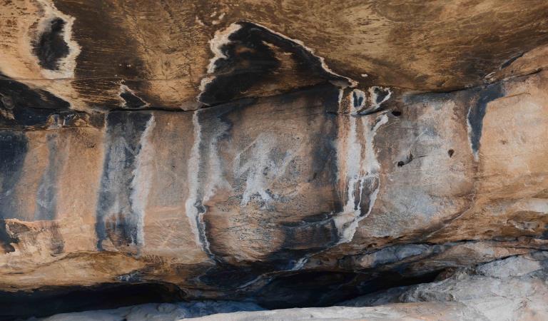 Rock art of a human-shape figure holding a spear