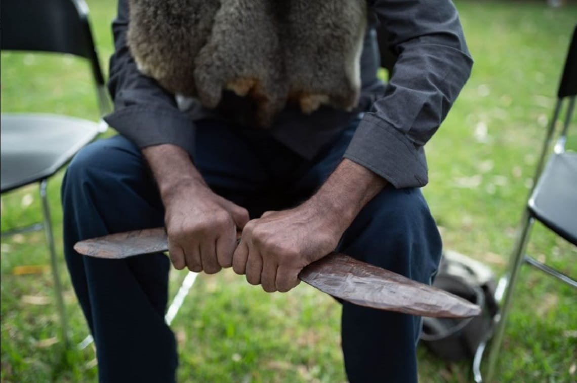 Person sitting down and sharing cultural knowledge