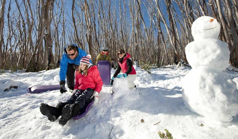 A family plays in the snow at Mt St-Gwinear in the Baw Baw National Park.