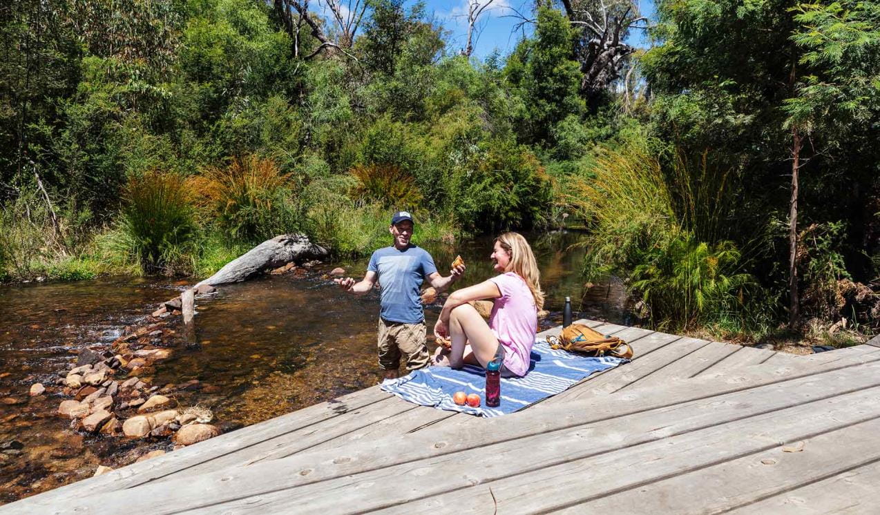 A couple enjoy a picnic by the MacKenzie river at Zumsteins Historic Area.