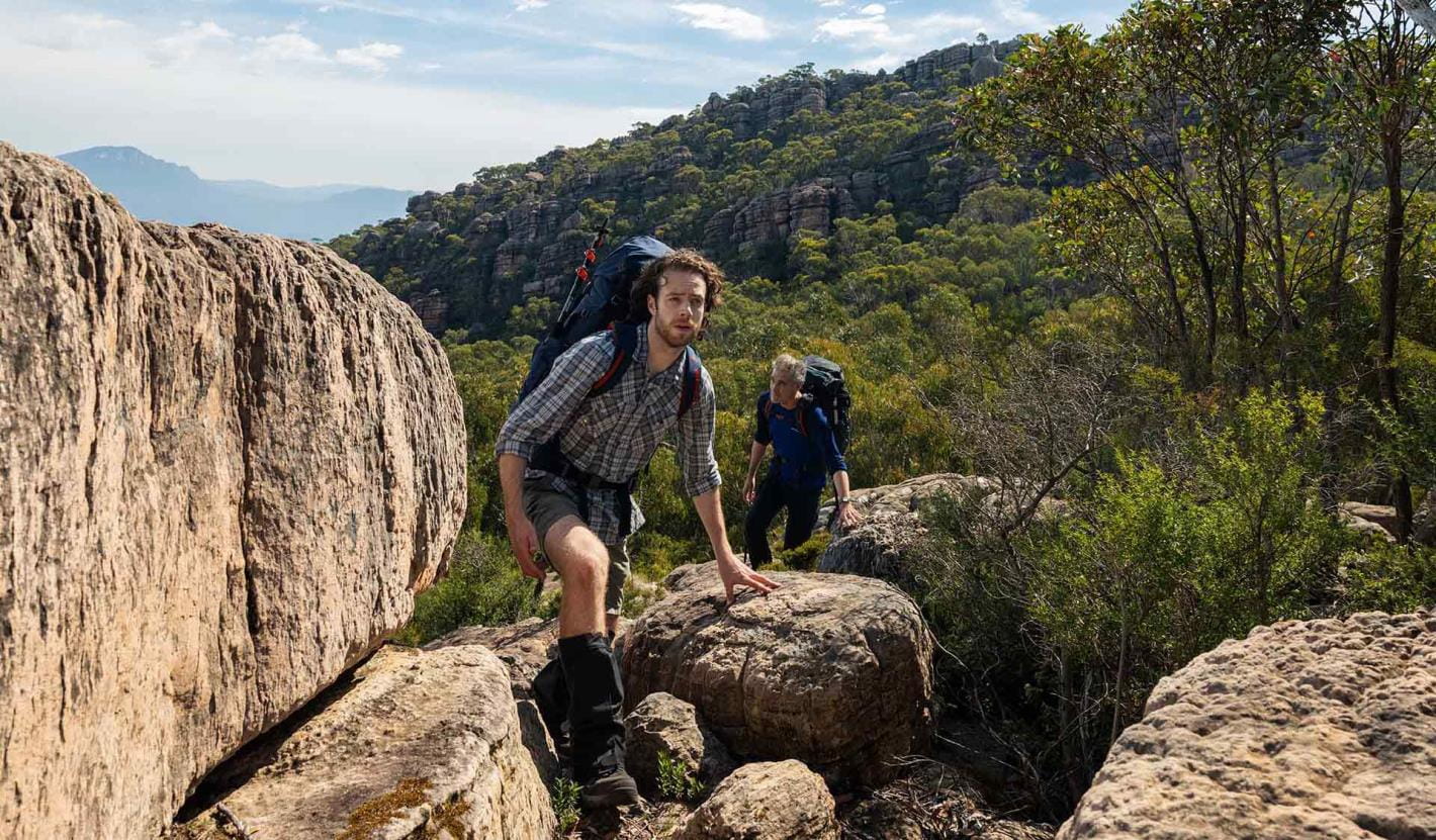 Two friends clamber between two boulders nears the Seven Dials on central section 3 of the GPT