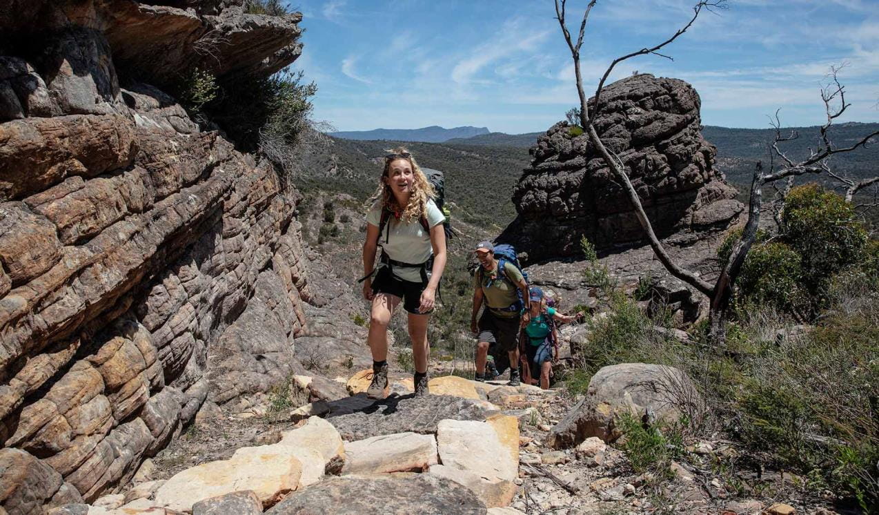 A group climbs up through the mid-sections of Gar / Mount Difficult