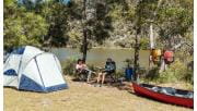 Two campers relax at their campsite after a long paddle.