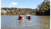 A woman playfully splashing a friend in another canoe with her paddle on the Glenelg River