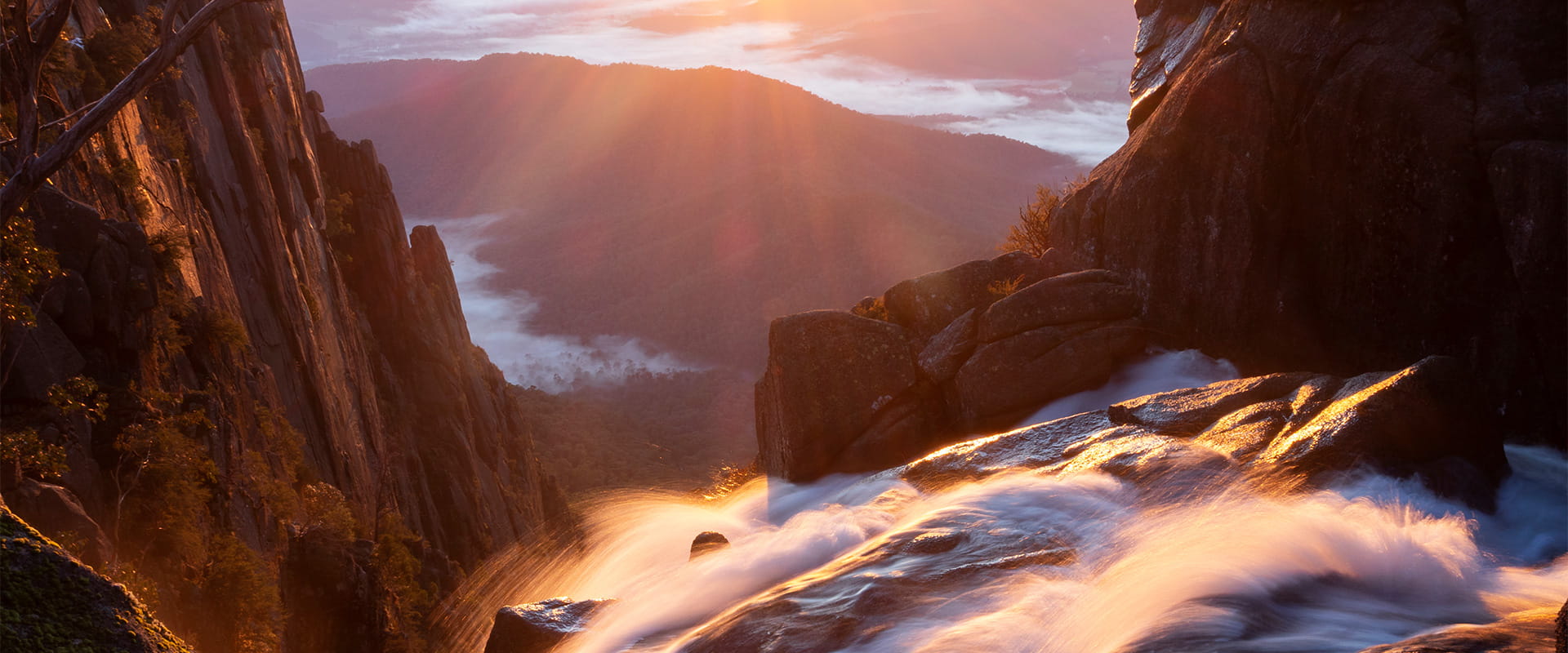 Water cascading over rocks in the mountains at sunrise.