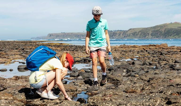 Two children walk through the rockpools at Mushroom Reef. 