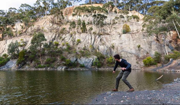 A man skims a rock along the water at Blue Lake at Plenty Gorge Park