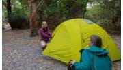 Two hikers set up a yellow tent near Halfway Hut on the Southern Circuit hiking trail at Wilsons Promontory National Park