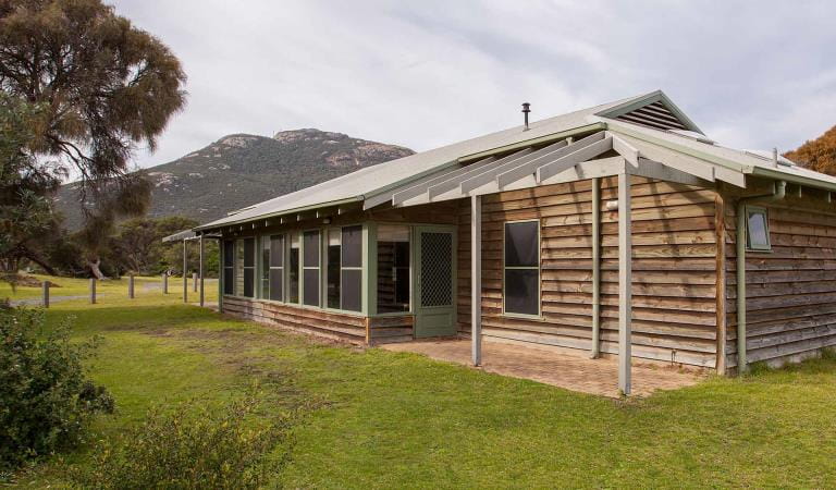 The exterior of a group lodge in Tidal River with Mount Oberon in the background at Wilsons Promontory National Park
