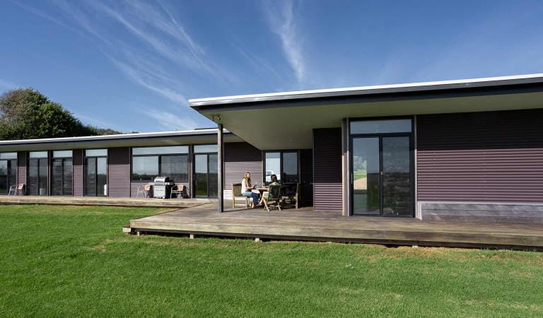 The friends enjoy a drink on the deck of Just Inside the Gate at Wilsons Promontory National Park