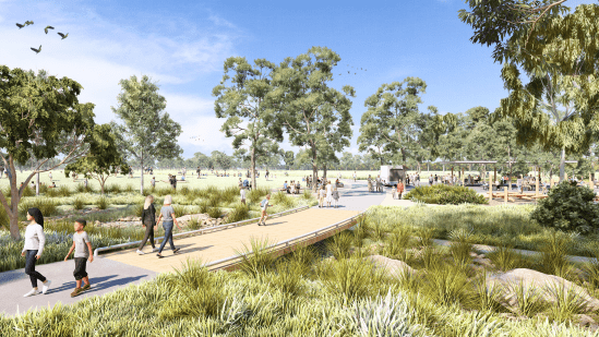 Main visitor area showing places to picnic, BBQ and relax people are walking on paths and sitting on open lawns with a blue sky and tall native trees in the background