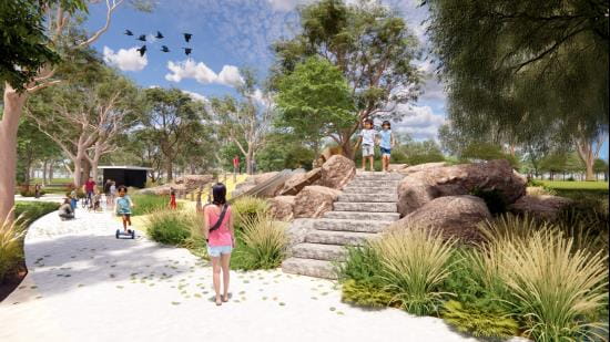 Open nature themed play area with walking path circling play equipment and tall trees behind