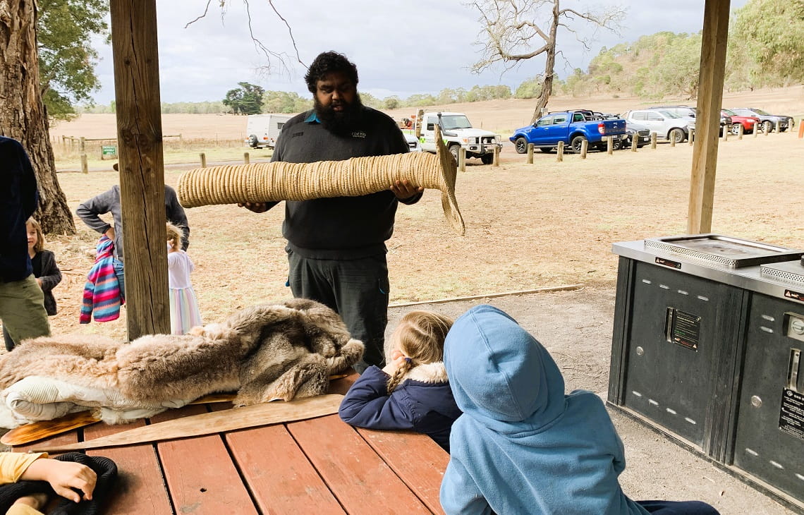 Braydon Saunders shows Junior Rangers an eel trap basket 