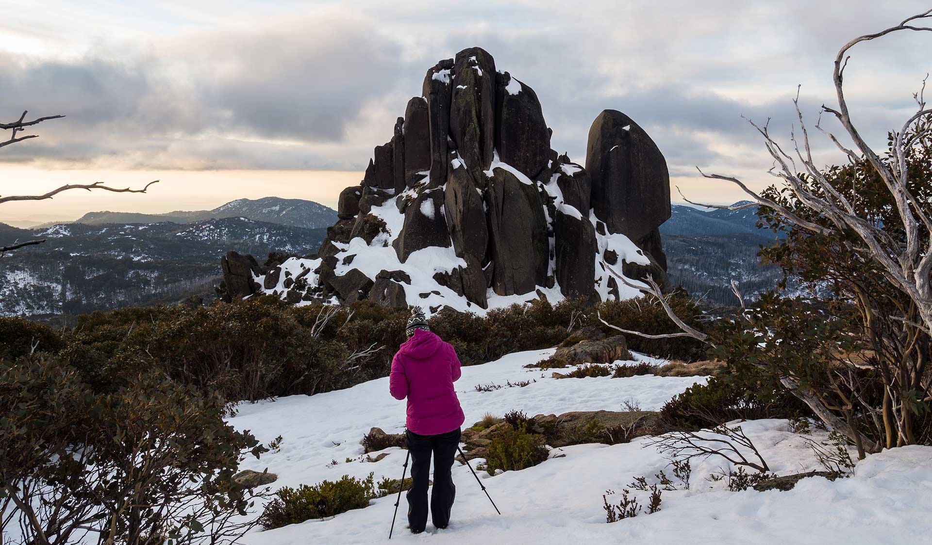 A women takes a photo of the Cathedral at Mount Buffalo National Park.