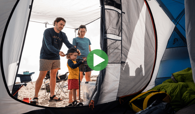 A family cooking dinner outside their tent