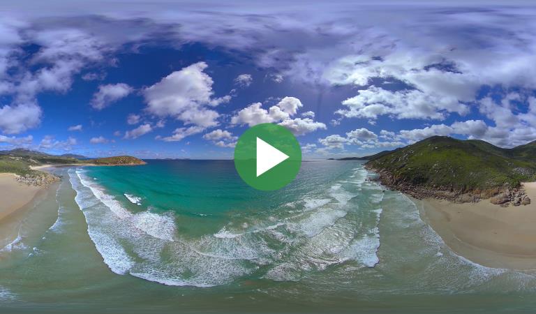 Wide view of the water and beach at Wilsons Promontory National Park with video play icon overlay
