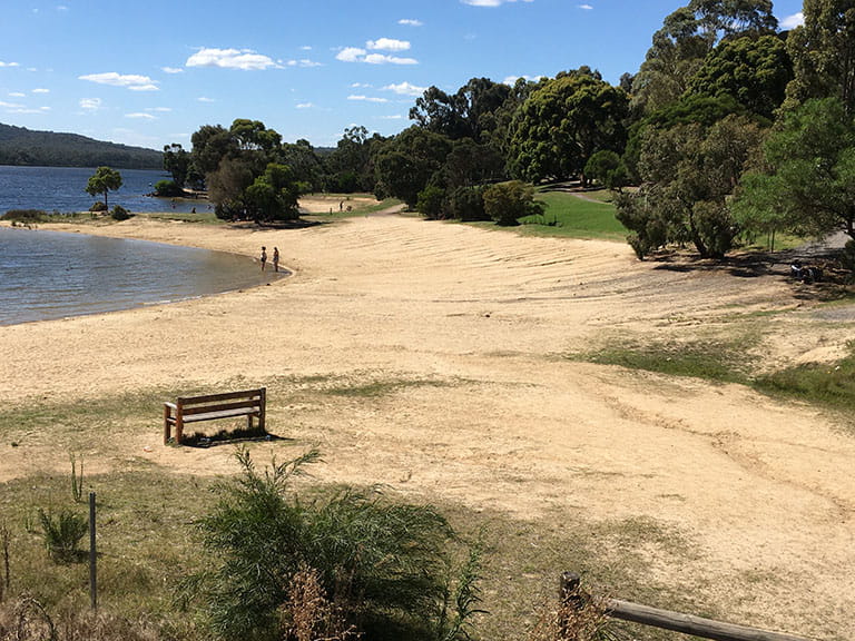 Beach area with bench near the dam wall at Lysterfield Park.