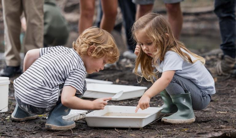 Two children playing with draining pan