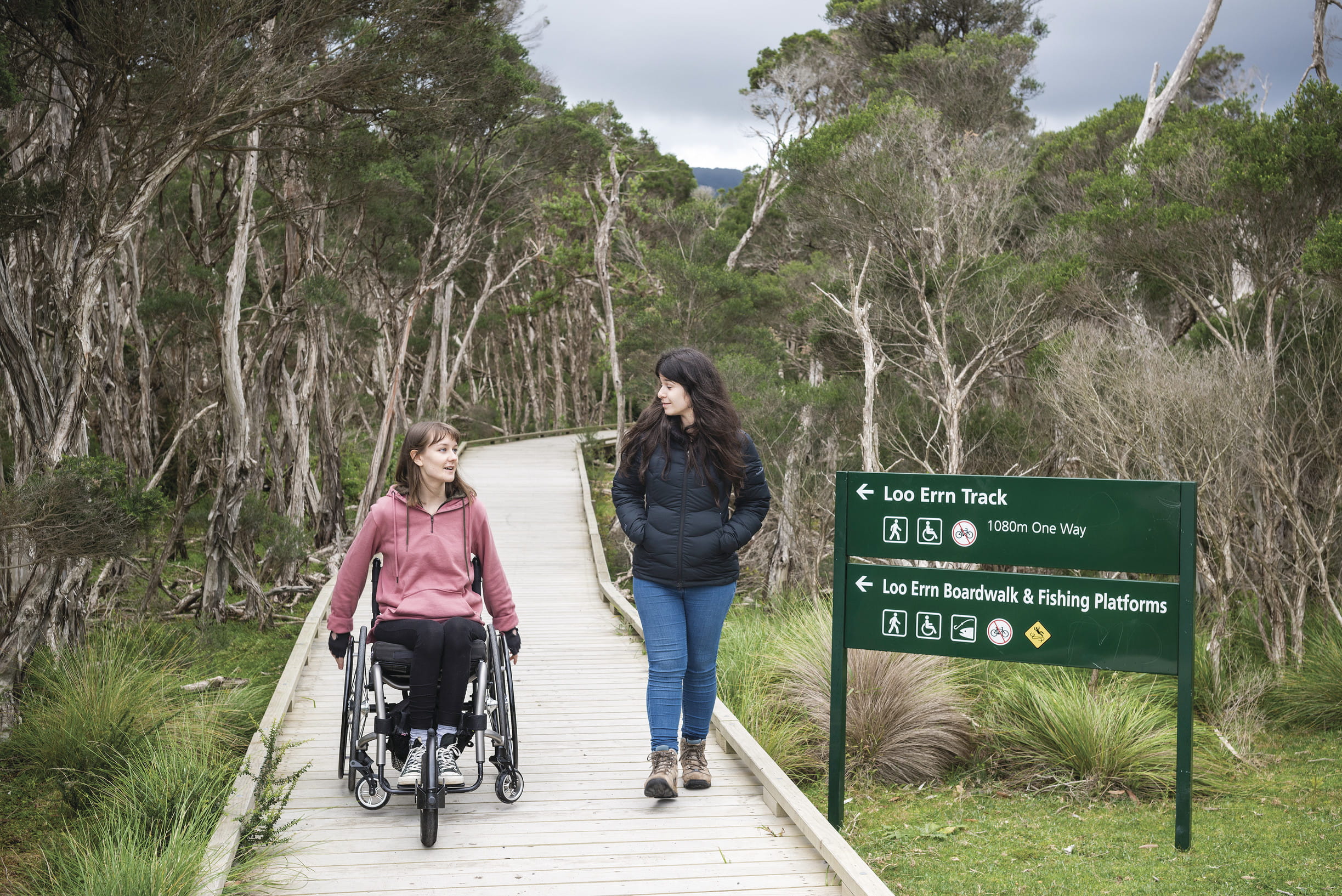 Person in wheelchair and second person walking along boardwalk at Wilsons Promontory National Park