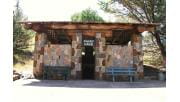 The Fairy Caves entrance before it was damaged in the fires. It has a stone facade and a log timber roof.