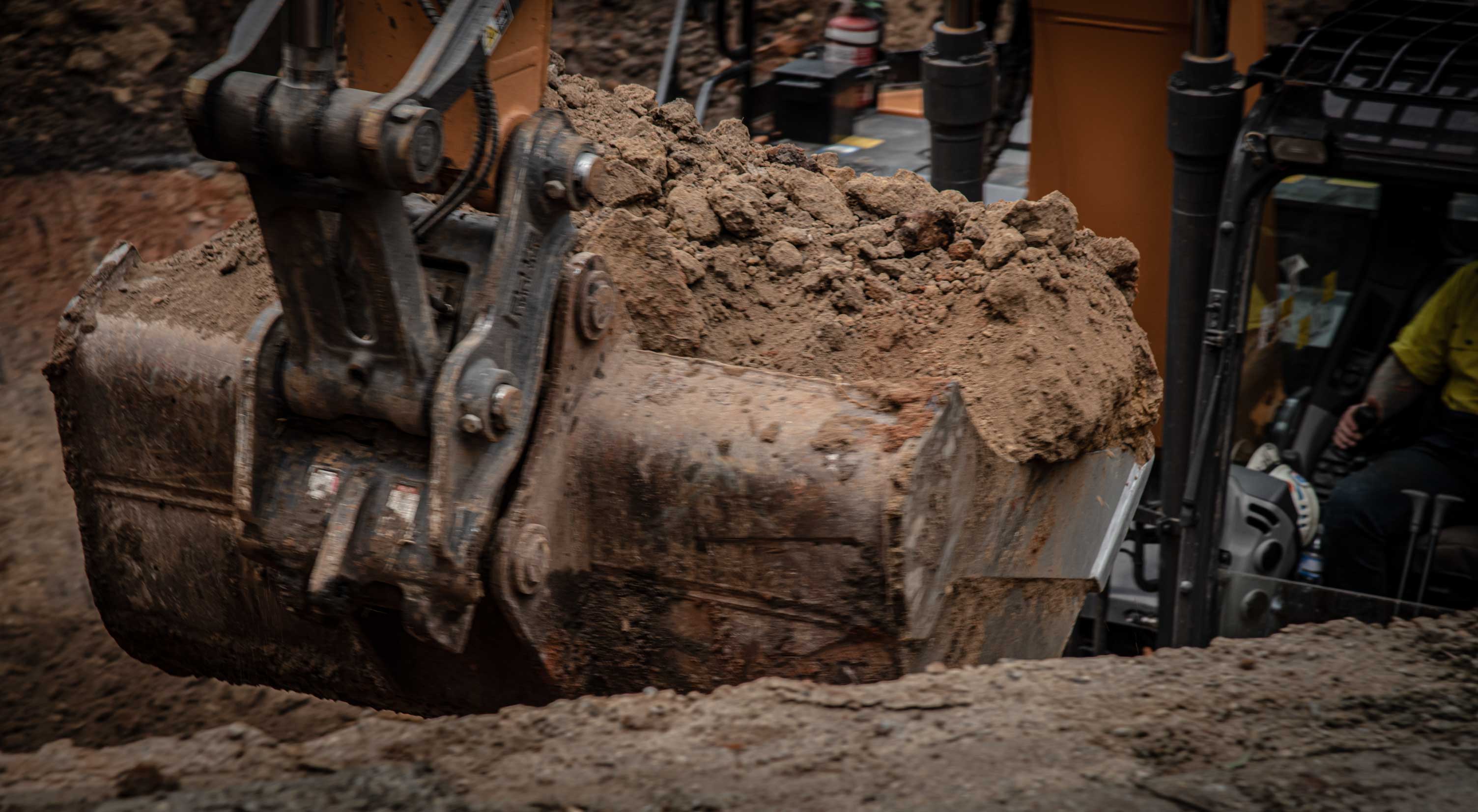 Excavator moving earth during culvert replacement