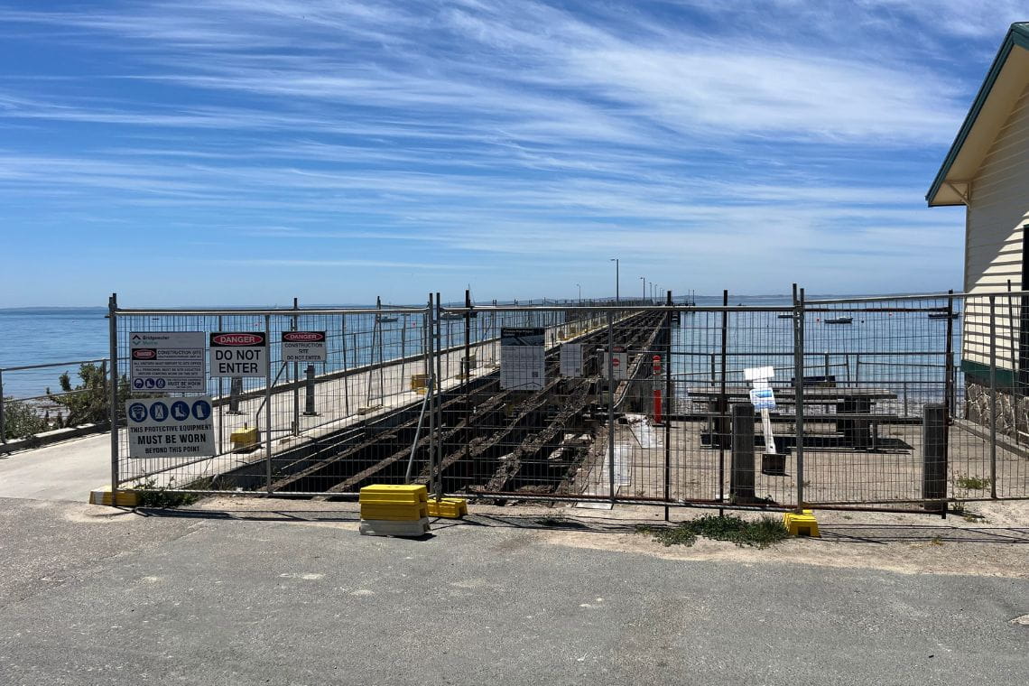 Gates and signs blocking access to the damaged Flinders Pier.