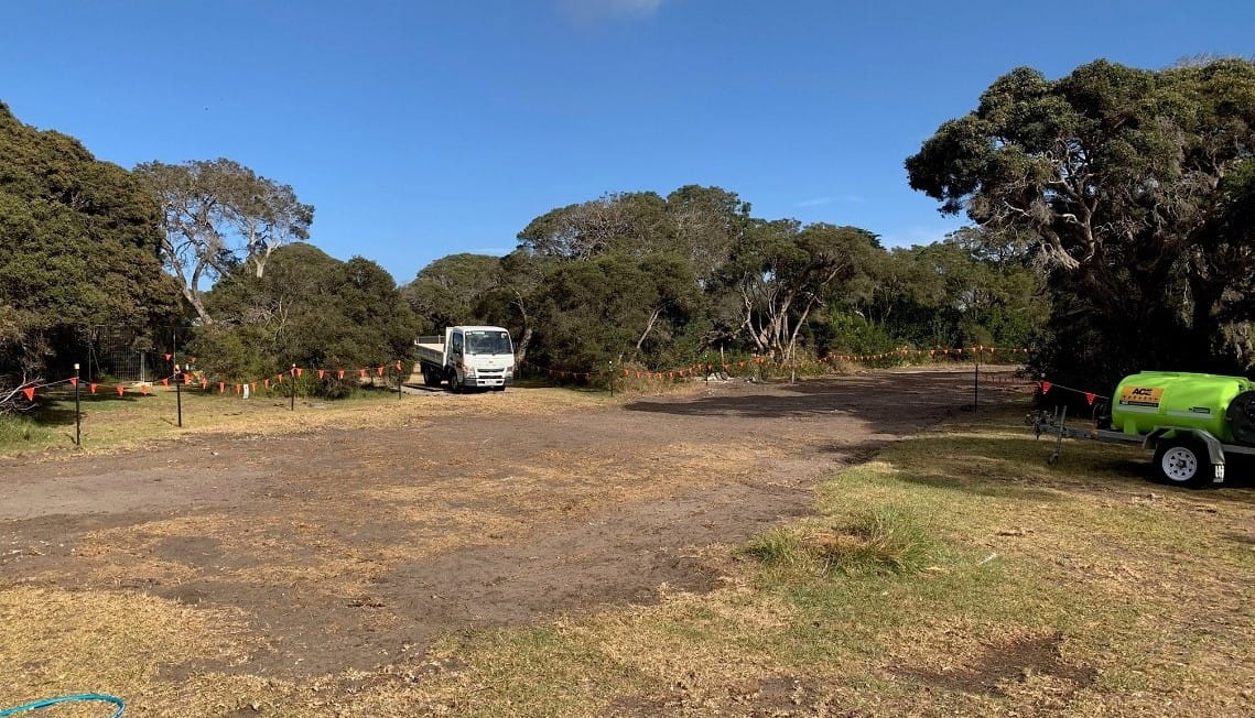 The site of the Point Nepean National Park campground expansion after demolition. A sandy clearing is surrounded by trees. 