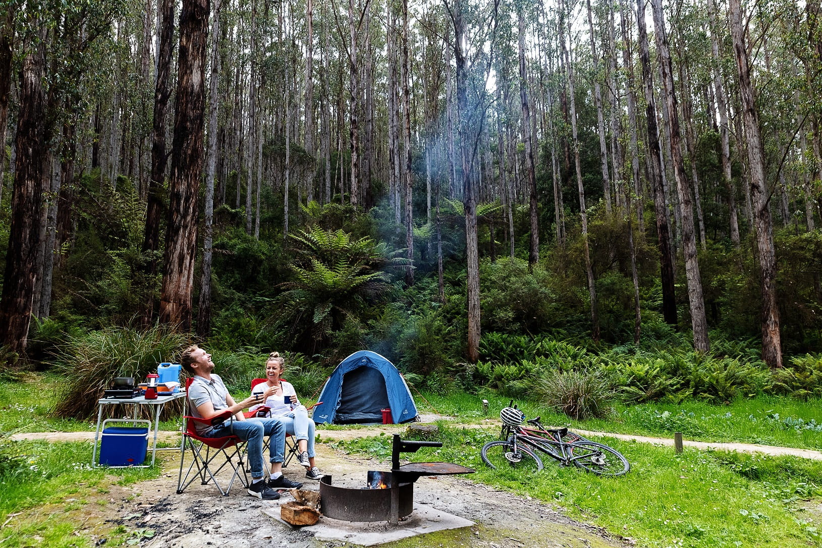 A couple relax at their campsite in the Victorian bush.