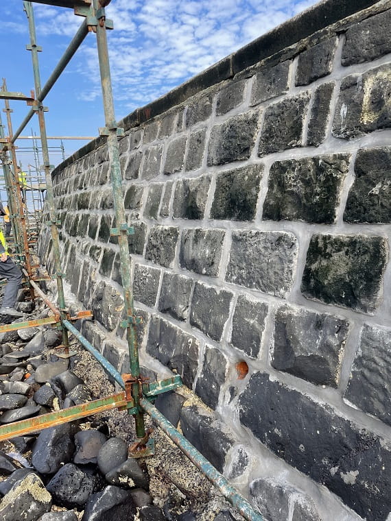 Like-for-like grout repairs are being made to the bluestone seawall at Point Gellibrand Coastal Heritage Park. Scaffolding is in place.