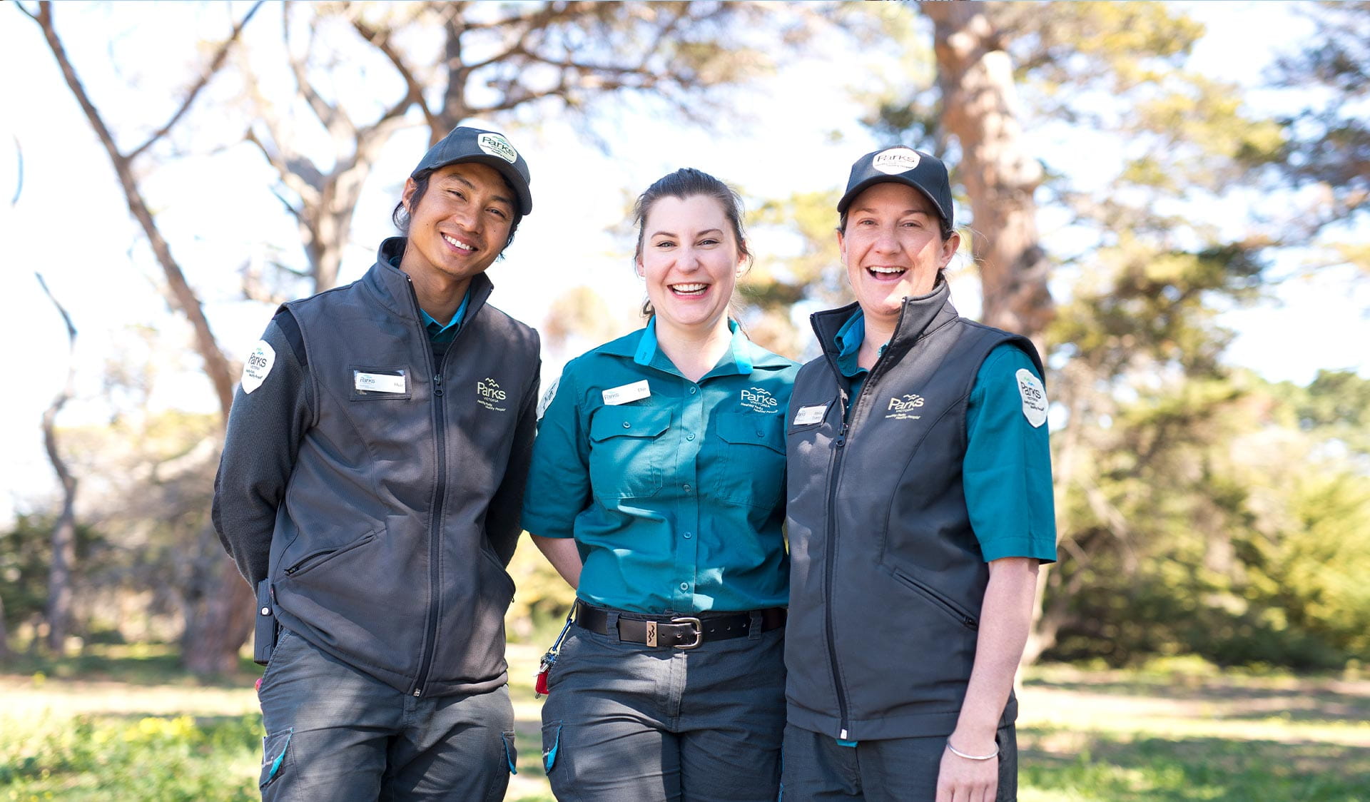 Three park rangers smiling.