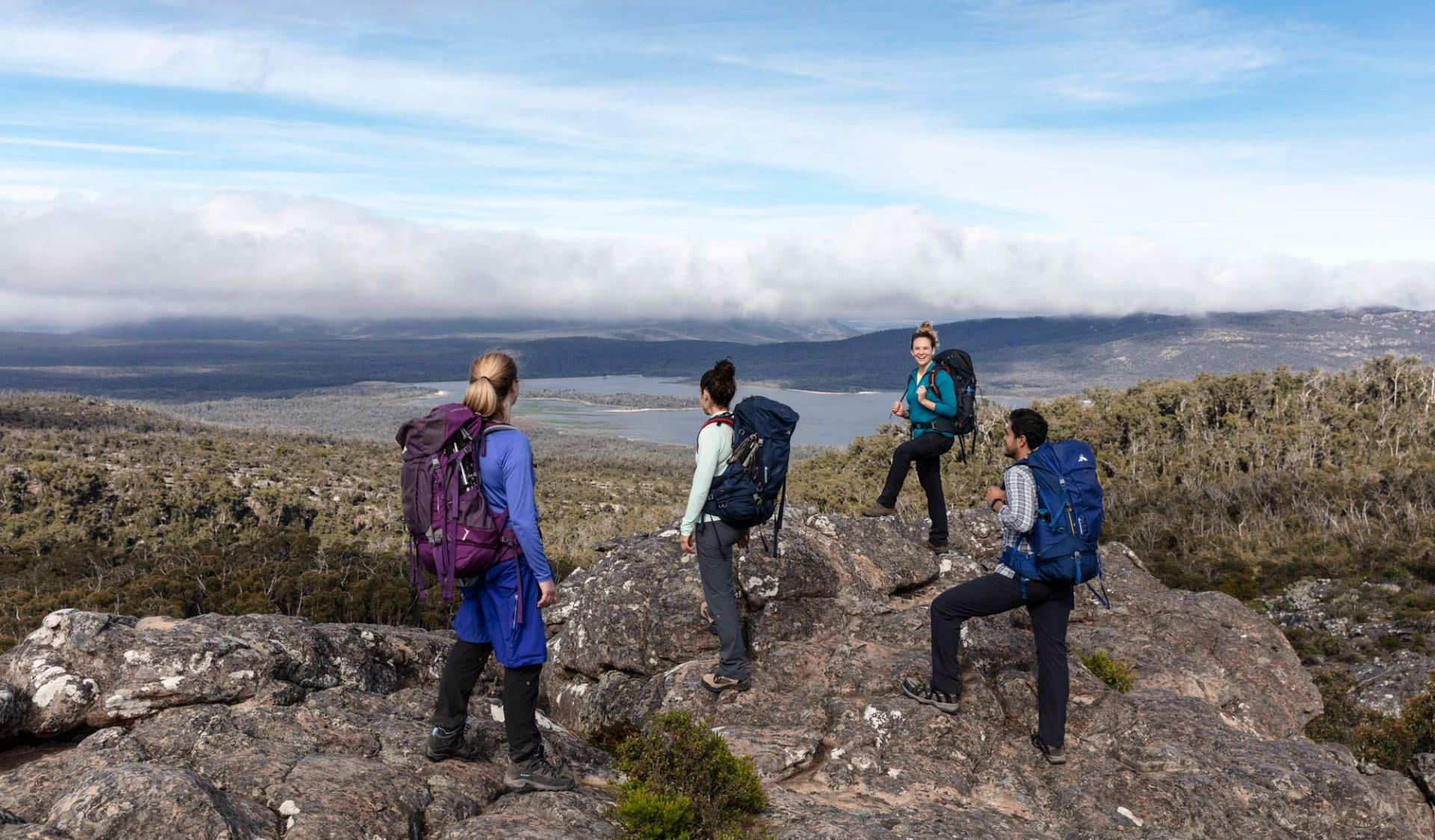 Four hikers standing on rocks looking at the horizon