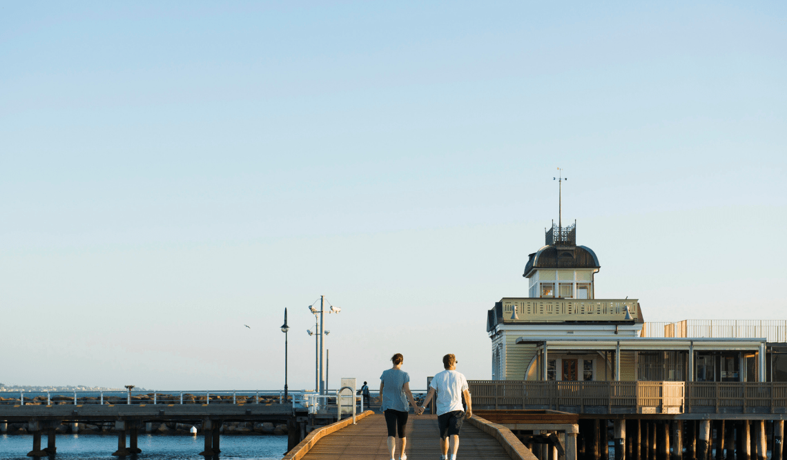 A couple walking along St Kilda Pier