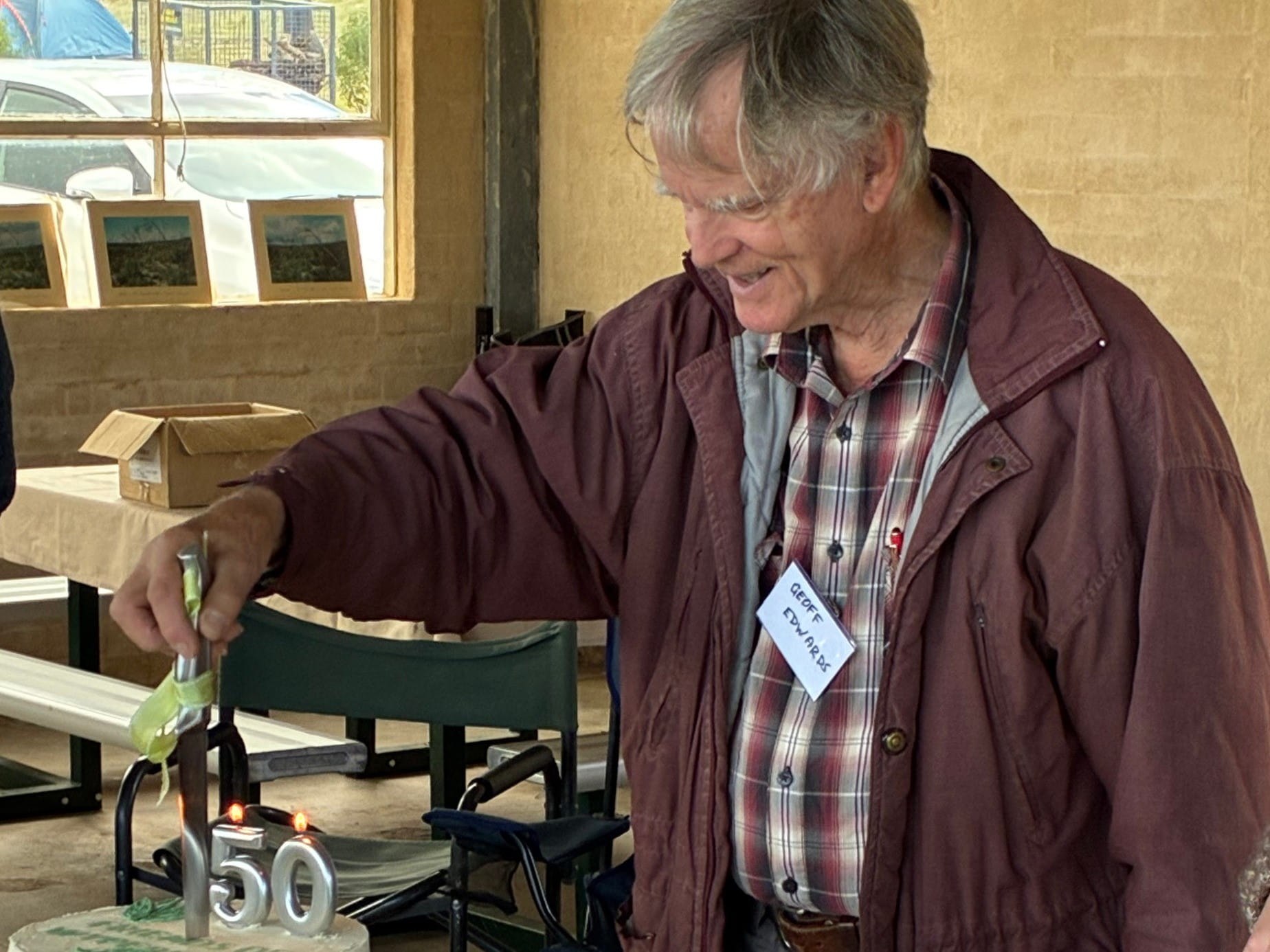 Founding member Geoff Edwards cutting cake
