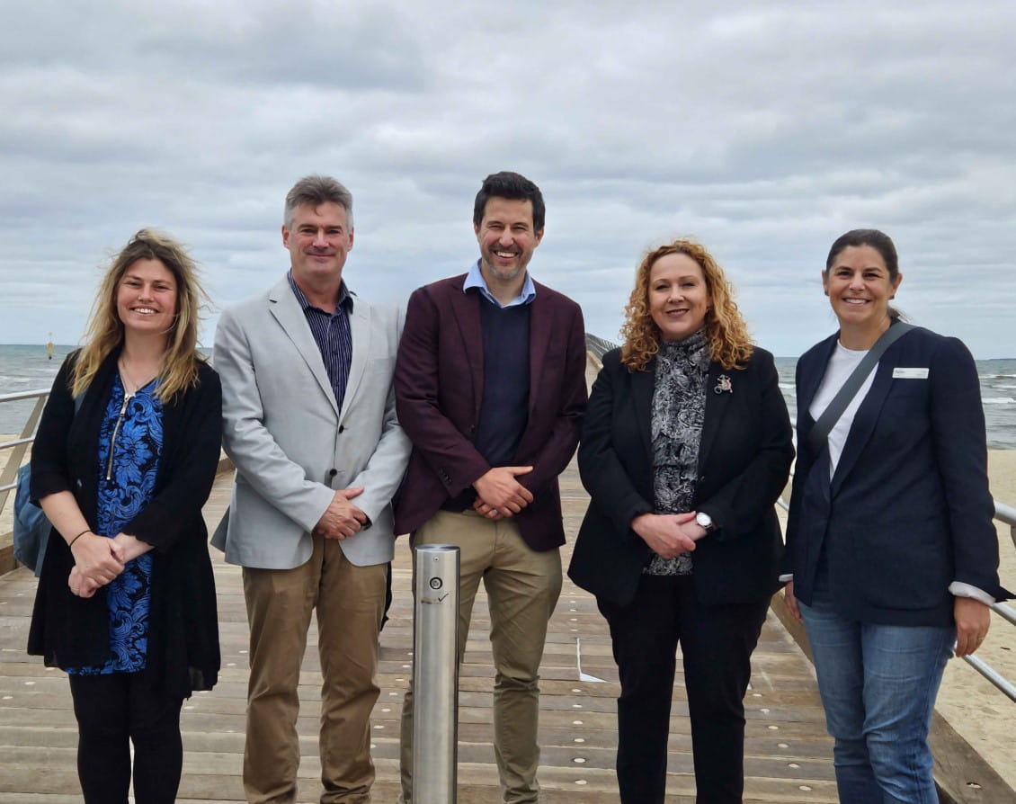 Five people stand on the new Altona Pier. They are Hobson's Bay Councillor Diana Grima, Parks Victoria Chief Executive Matthew Jackson, Hobson's Bay Mayor Matt Tyler, Minister for Ports and Freight Melissa Horne and Parks Victoria deputy chair Lisa Marty.