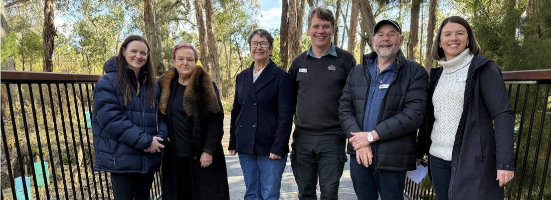 Parks Victoria representatives standing with key stakeholders on the new bridge leading to Woowookarung's 10,000 Steps Loop