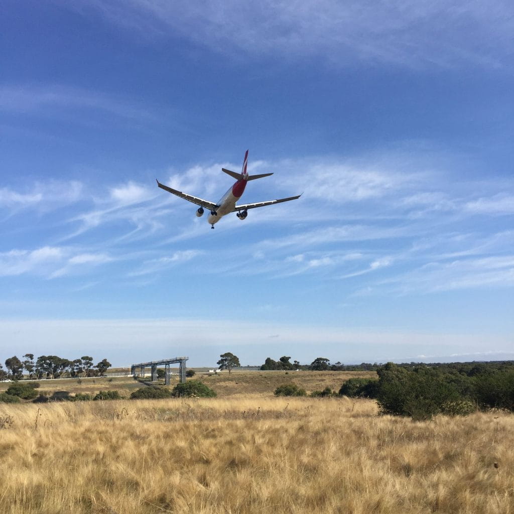 A plane flying in clear blue skies over Woodlands Historic Park.
