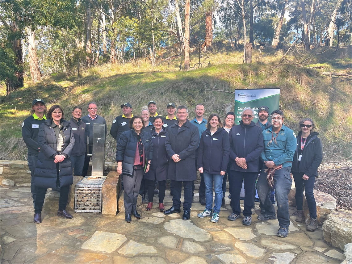 a large group of people standing next to a water pump