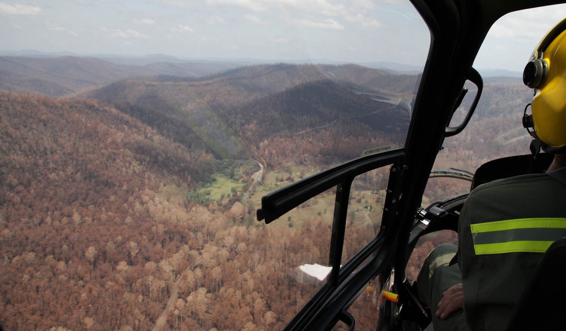 The view from the cockpit of the firefighting helicopter of recently burned forest. 