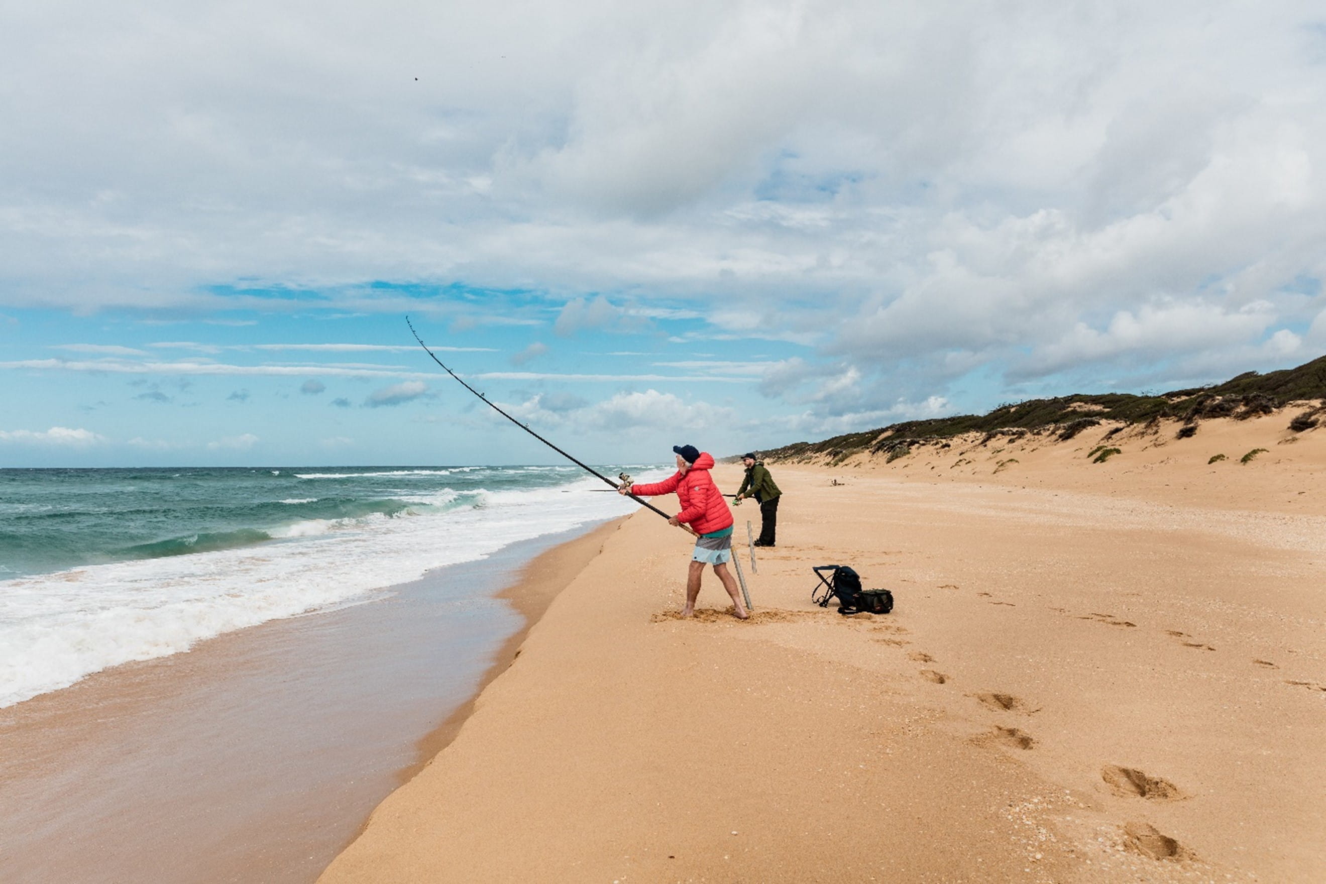 A person fishing at the beach with a fishing rod