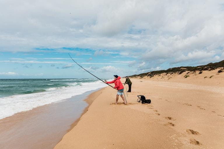 A person fishing at the beach with a fishing rod