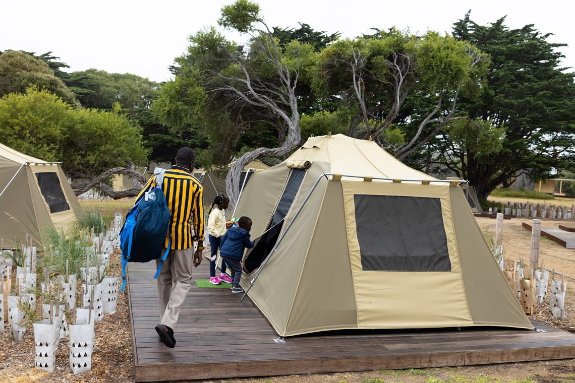 Father and children walking towards the opening of a Discovery Tent at Point Nepean National Park