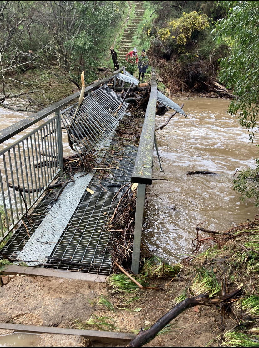 A damaged bridge over a swollen river