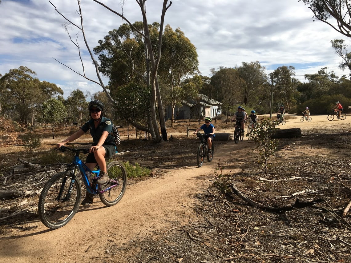 Group of riders cycling along path