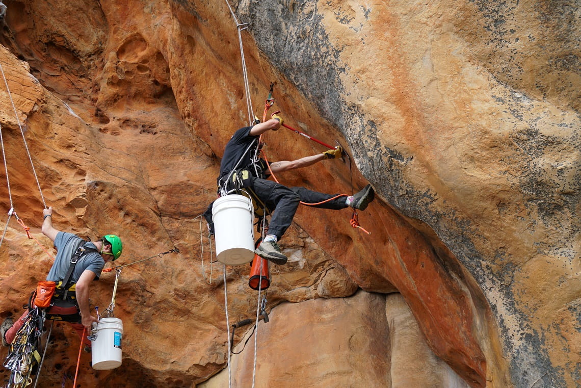 Specialist rope access technicians from the climbing community carry out the rehabilitation work in a Gariwerd Rock Art Shelter.