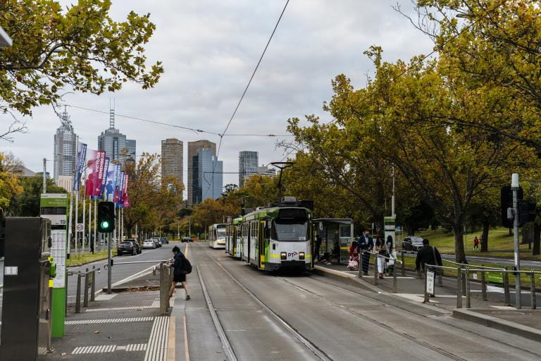 Tram on St Kilda Road in Melbourne with city skyline in background