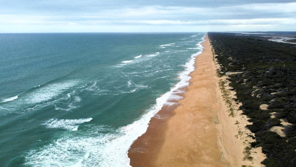 A long beach with bright yellow sand