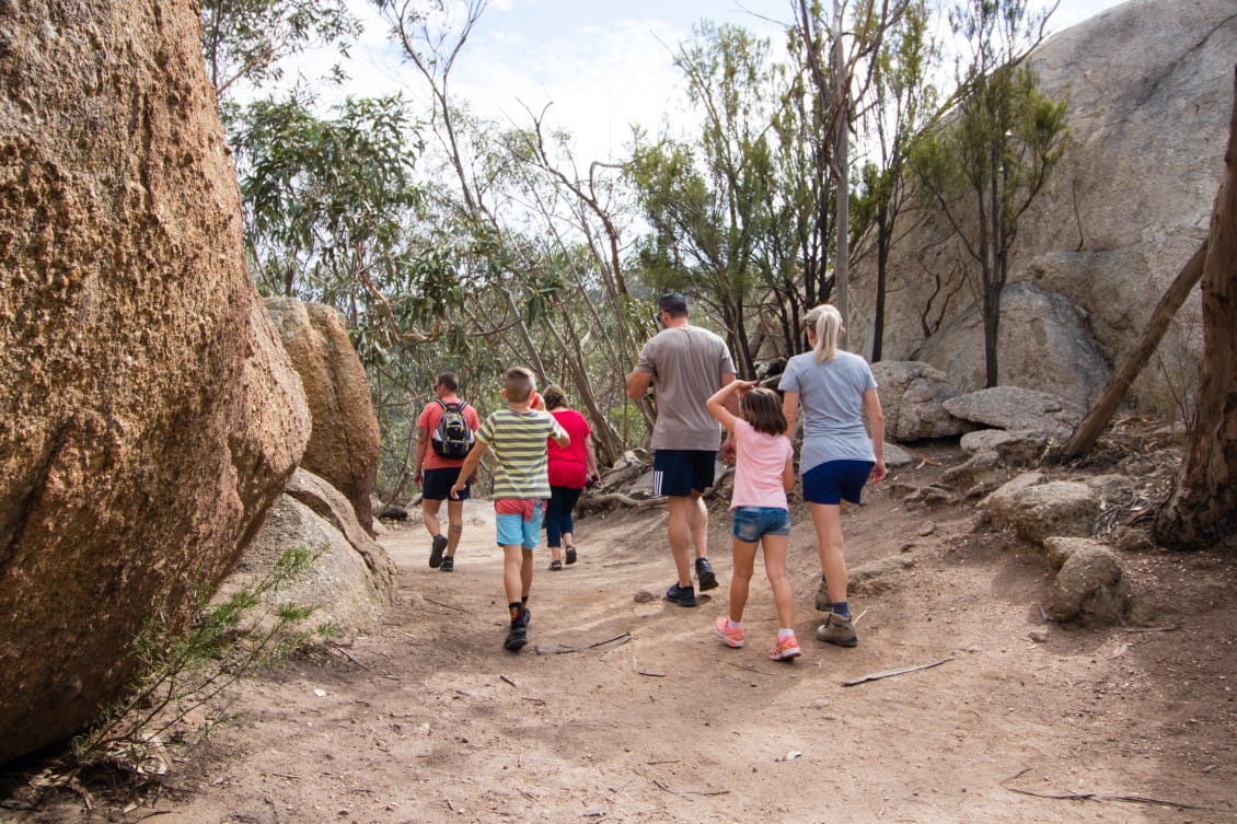 A family walk through two large boulders in the You Yangs Regional Park