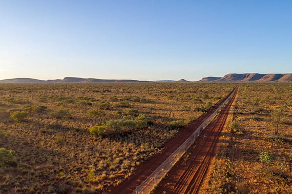 a desert landscape with a fence stretching across it